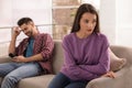 Young man preferring smartphone over his girlfriend on couch