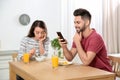 Young man preferring smartphone over his girlfriend