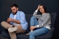 Young man preferring smartphone over his girlfriend at home. Relationship problems Royalty Free Stock Photo