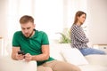 Man preferring smartphone over his girlfriend at home. Relationship problems