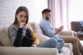 Young man preferring smartphone over girlfriend at home. Relationship problems