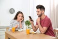 Young man preferring smartphone over his girlfriend