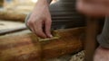 Young man prepares wood to build home construction by traditional way