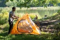 Young man preparing camping tent against river Royalty Free Stock Photo