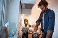 Young man preparing a meal on a stove in the kitchen. Kitchen, housework, quarantin, home Royalty Free Stock Photo