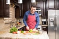 Young man preparing salad in kitchen Royalty Free Stock Photo