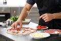 Young man preparing tasty pizza at table Royalty Free Stock Photo