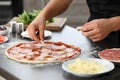 Young man preparing tasty pizza at table Royalty Free Stock Photo