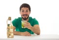 Young man presents a glass with lemon-based cocktail and cachaca.