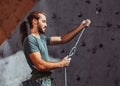 Young man professional rock climber checking sports equipment before climbing at training center in sunny day, outdoors Royalty Free Stock Photo