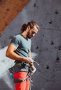 Young man professional rock climber checking sports equipment before climbing at training center in sunny day, outdoors Royalty Free Stock Photo