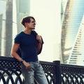 Young man in profile posing in fashion sun glasses, holding the