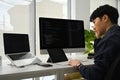 Young man programmer working on computer to check coding in bugging system in IT office