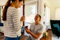 Young man proposing his girlfriend with ring at home. Asian woman getting surprised by her boyfriend with marriage Royalty Free Stock Photo