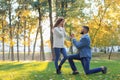 Young man proposing to his beloved in autumn park Royalty Free Stock Photo