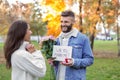 Young man proposing to his beloved in autumn park Royalty Free Stock Photo