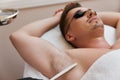 young man undergoes procedure of arm pit laser epilation Royalty Free Stock Photo