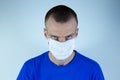 Young man in a protective mask on a blue background. Angry, stubborn, strict. Central location Royalty Free Stock Photo