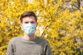 Young man in protective mask near blooming tree. Allergy concept Royalty Free Stock Photo