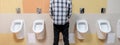 a young man in the public toilet, standing next to the urinal in the trade center Royalty Free Stock Photo