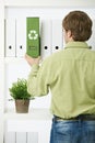 Young man pulling out green folder