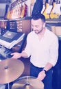 Young man purchasing professional drum set in store