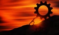 Young man Pushing Gear Uphill At sunset. Businessman Push The Heavy Cogwheel up the top of mountain. Sisyphus