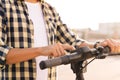 Young man is pushing start button of modern gadget and driving along street of city. Closeup male hands on wheel of Royalty Free Stock Photo