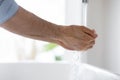 Young man put hands under running from tap water. Royalty Free Stock Photo