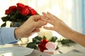 Young man putting engagement ring on fiancee's finger at romantic date Royalty Free Stock Photo