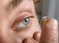 Young man putting lens in his eye, closeup Royalty Free Stock Photo