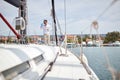 A young man quenches his thirst under hot sun while riding on the yacht on the seaside. Summer, sea, vacation