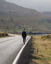 Young man on a quiet country road in the middle of a rural landscape