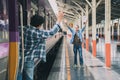 A young man raised hands to greet his friend who was arriving by the train