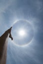 The young man raised his hand to the sky when he saw the natural phenomenon around the sun and made a religious homage to ask for