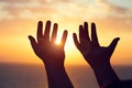 Young man raising hands praying at sunset or sunrise light Royalty Free Stock Photo