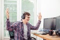 Young man raising his arms in his office