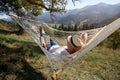 Young man reading book in hammock outdoors on sunny day Royalty Free Stock Photo