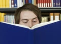 Young Man Reading Book In Library Royalty Free Stock Photo