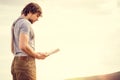 Young Man reading book outdoor with scandinavian lake on background Royalty Free Stock Photo