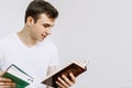 A young man is reading a book. Selects a book in the store. Isolated white background Royalty Free Stock Photo