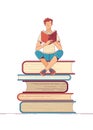 Young man reading book while sitting on stack of books Royalty Free Stock Photo