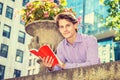 Young Man reading book, thinking, relaxing outside in New York