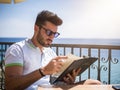 Young man reading menu at outdoor bar Royalty Free Stock Photo