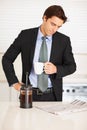 Young man reading newspaper while drinking coffee at home. Business executive reading newspaper while drinking a cup of Royalty Free Stock Photo