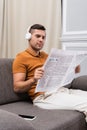 young man reading newspaper and listening Royalty Free Stock Photo