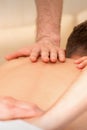 Young man receiving back massage in four hands in spa beauty salon. Royalty Free Stock Photo