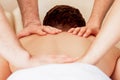 Man receiving back massage in four hands Royalty Free Stock Photo