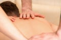 Young man receiving back massage in four hands in spa beauty salon. Royalty Free Stock Photo