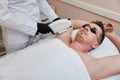 Young man receiving epilation in beauty center. laser hair removal procedure Royalty Free Stock Photo